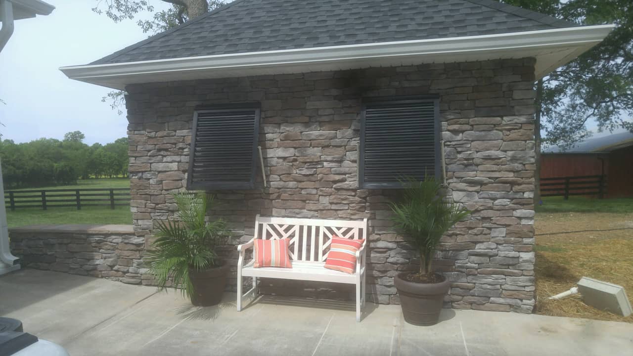 Bahama shutters on a stone garage