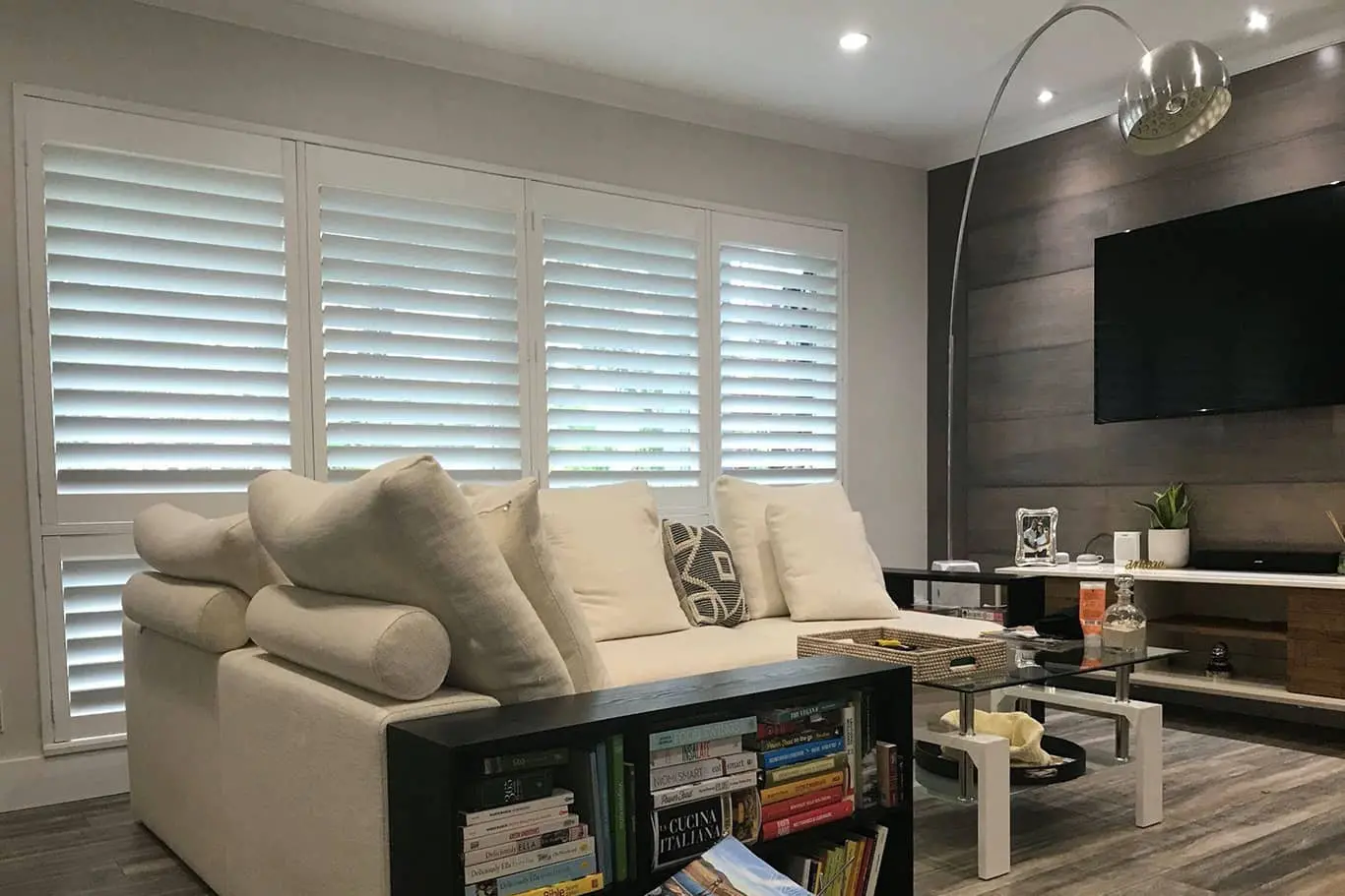 living room with plantation shutters and a white sofa