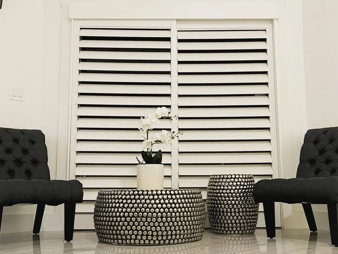 plantation shutters on a large window in a sitting room